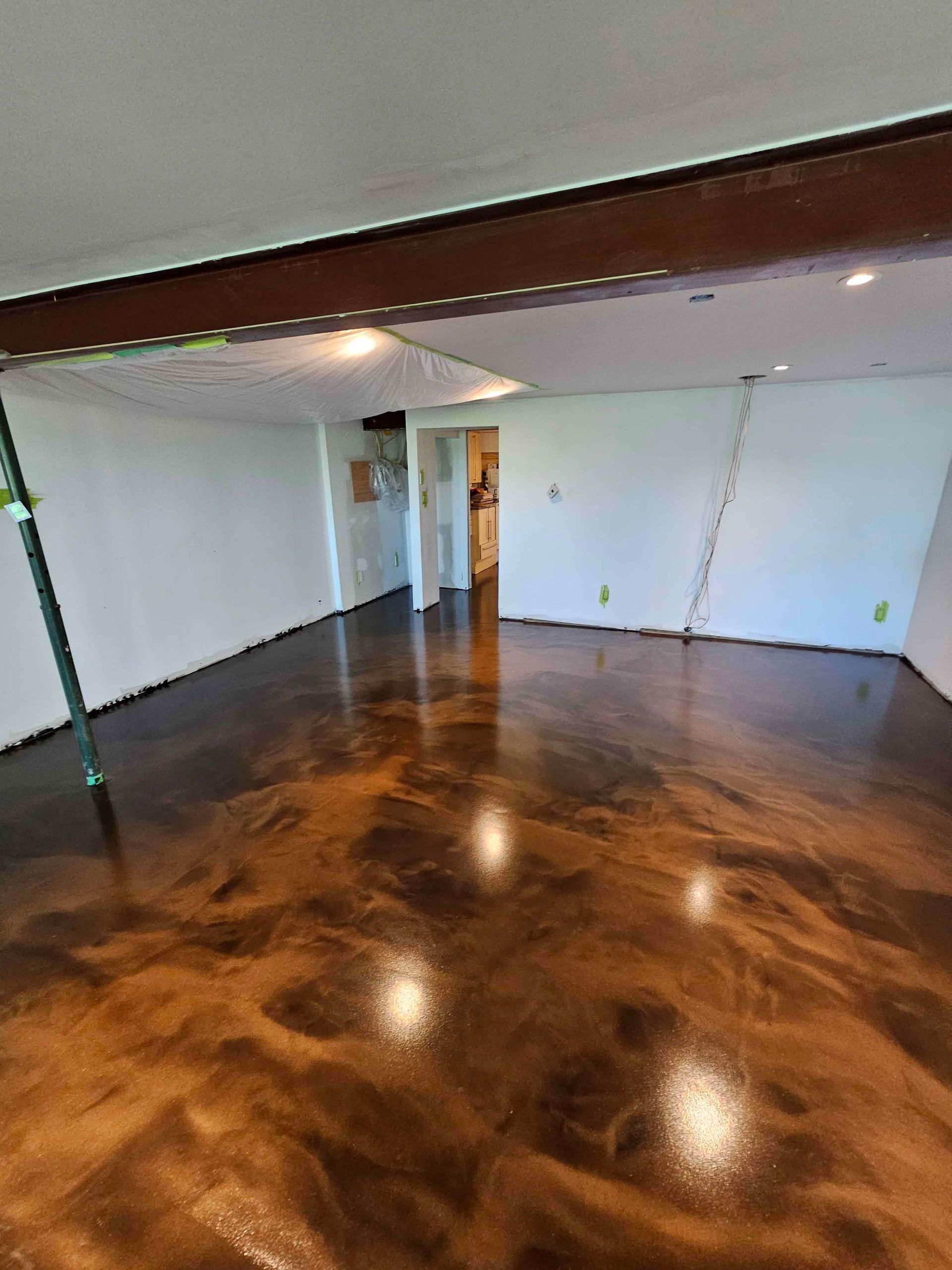 A living room with a brown metallic floor and white walls.