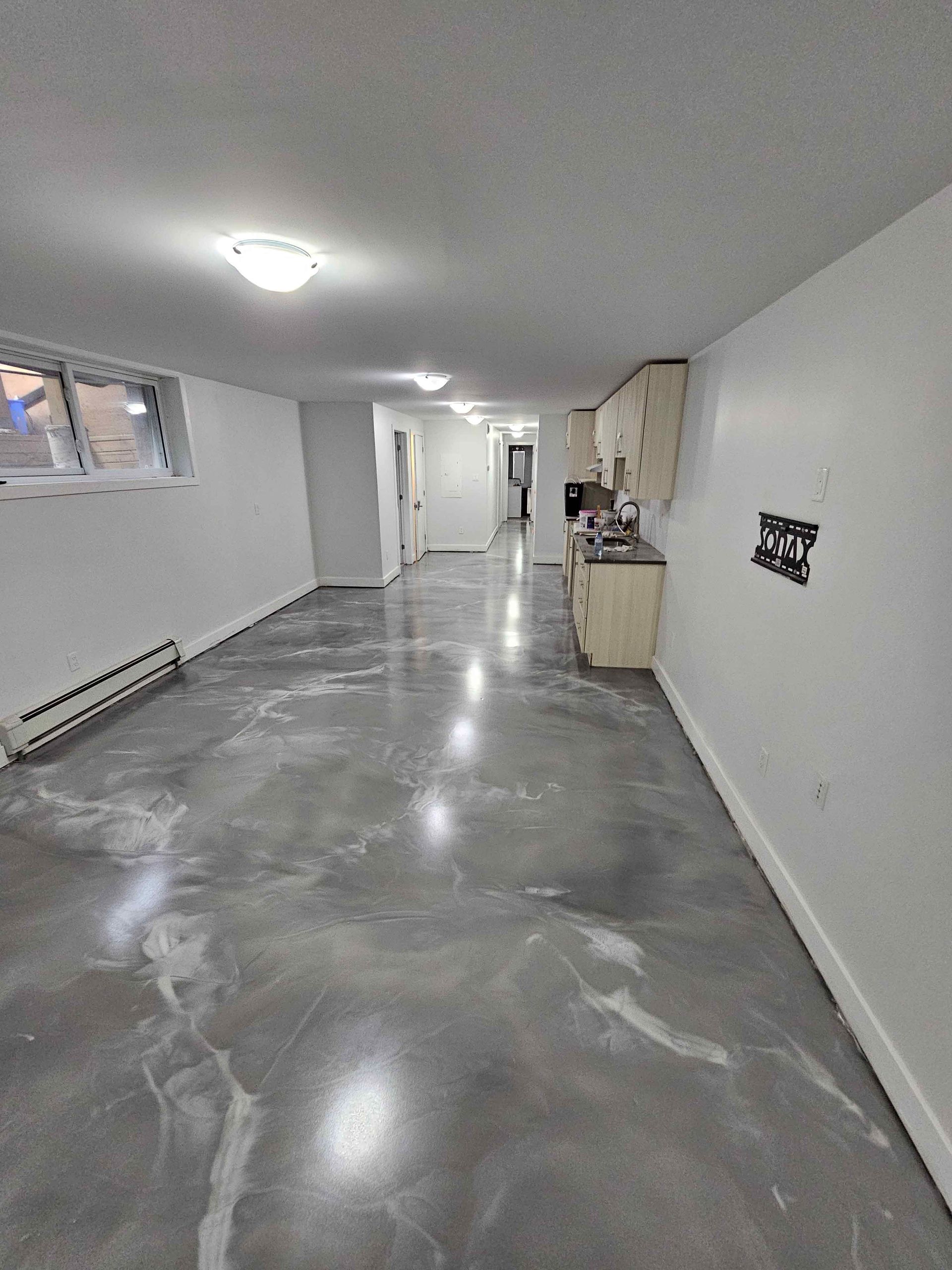 A large room with a shiny concrete floor and white walls.