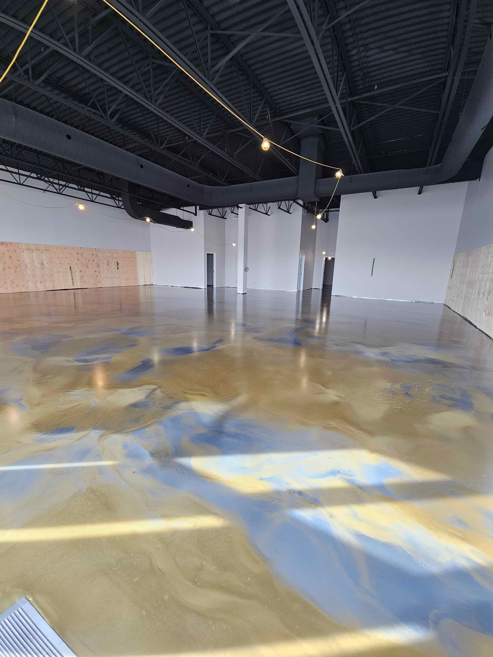A large empty room with a concrete floor and ceiling.