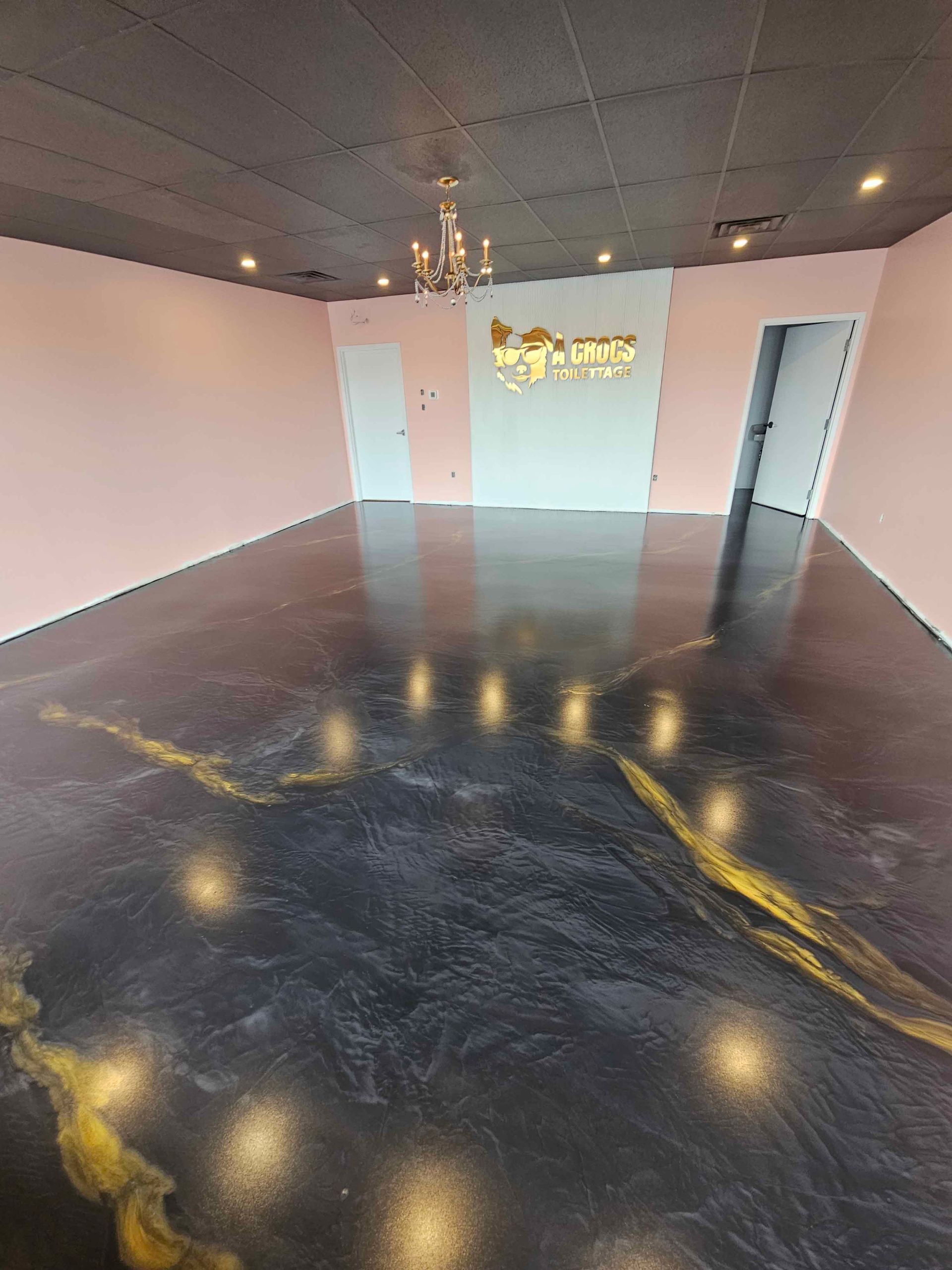 A large room with a black floor and a chandelier.