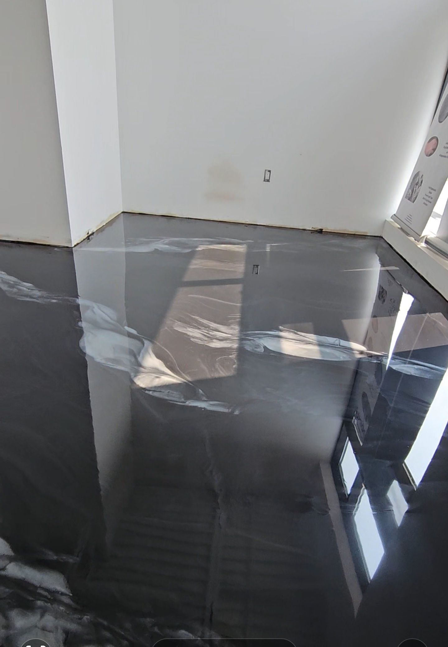 A room with a black metallic floor and white walls.