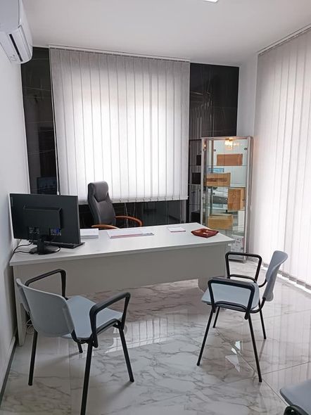 Un piccolo ufficio con una scrivania, sedie e un computer.