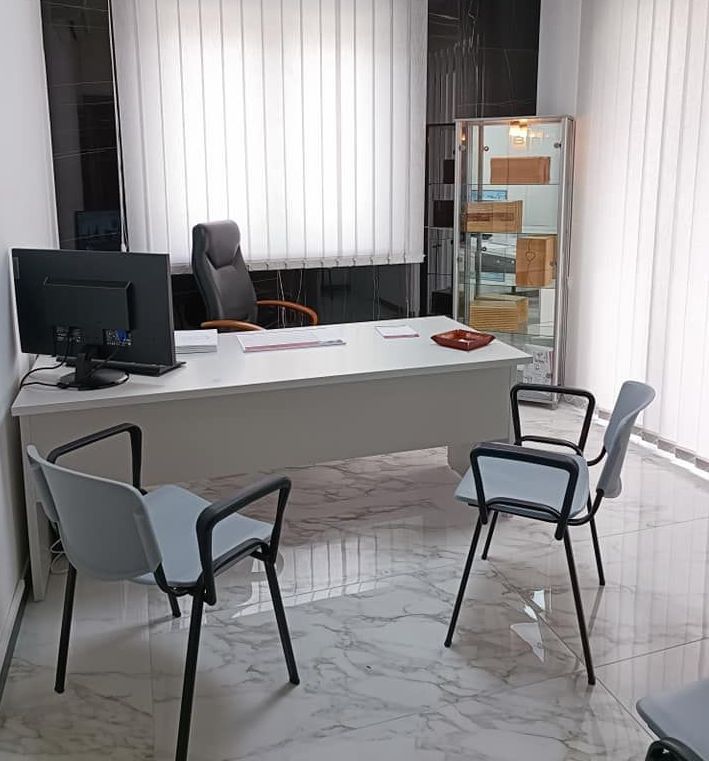 Una stanza con una scrivania, sedie e un computer.
