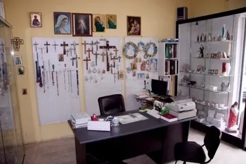Una scrivania e una sedia in una stanza con molte croci sul muro
