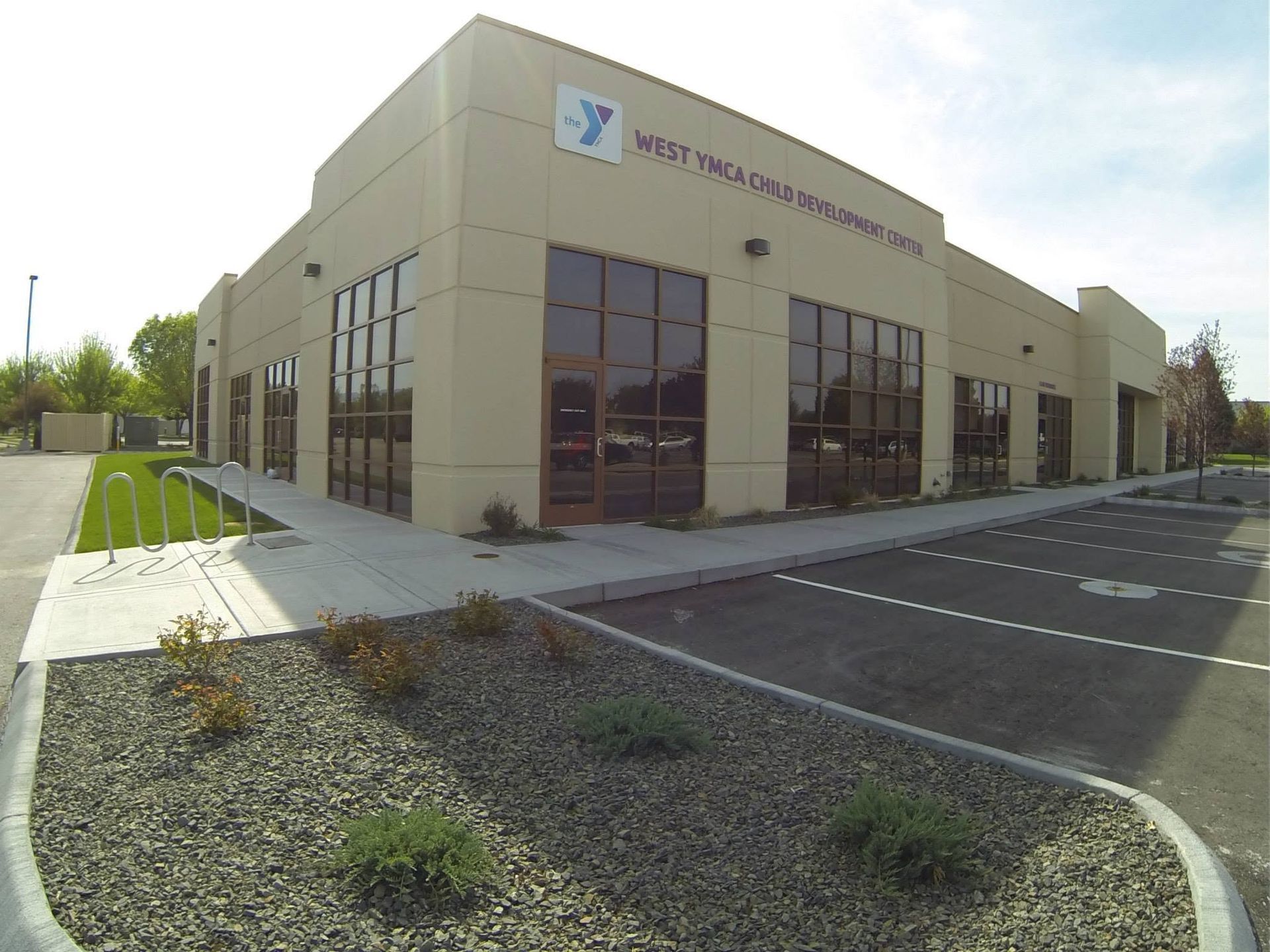 Modern medical office building with beige walls, large windows, and empty parking lot