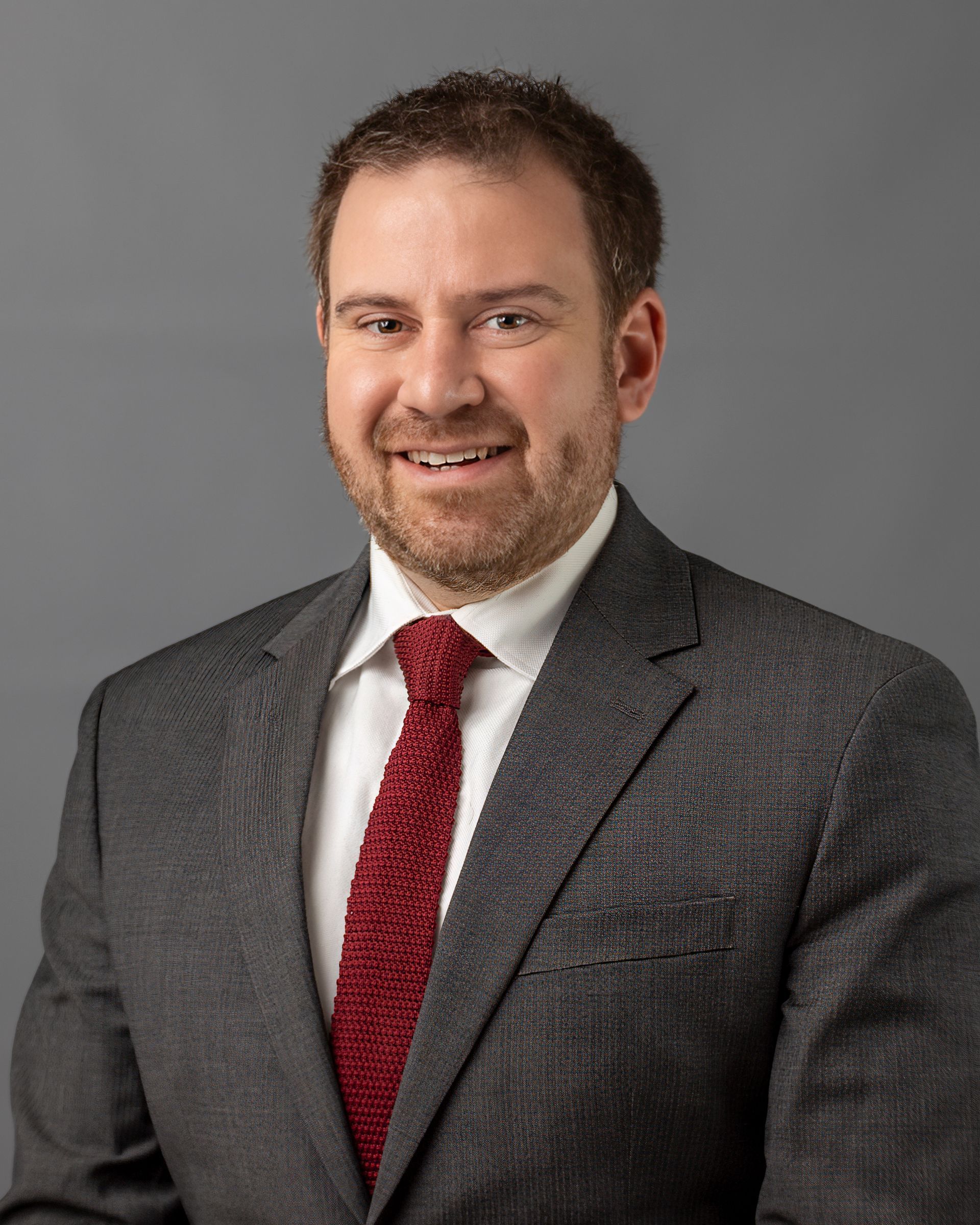 a man in a suit and tie is smiling for the camera .