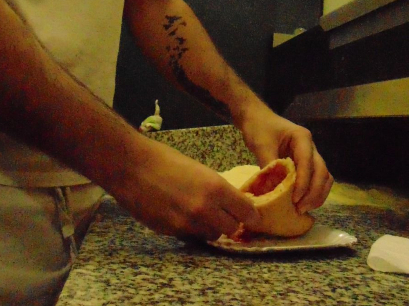 Persona che apre un calzone, rivelando un ripieno di salsa rossa.