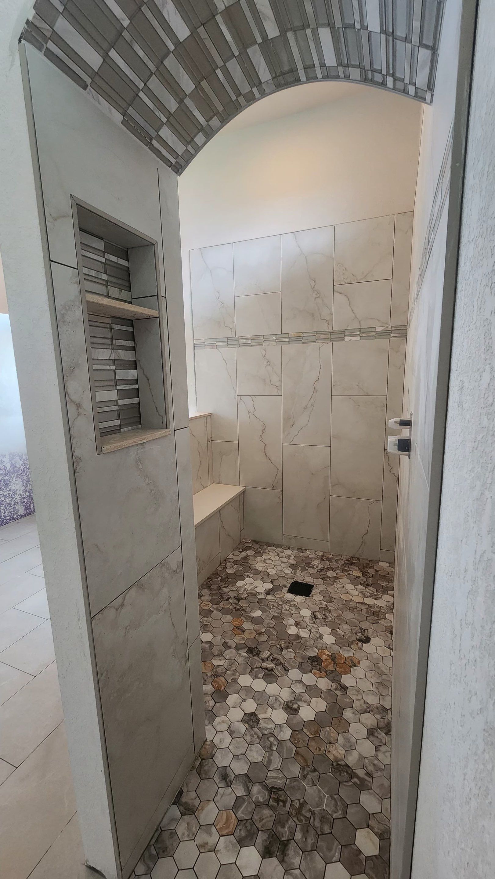 Custom arched tile shower entrance during bathroom remodeling project in Lakeland FL