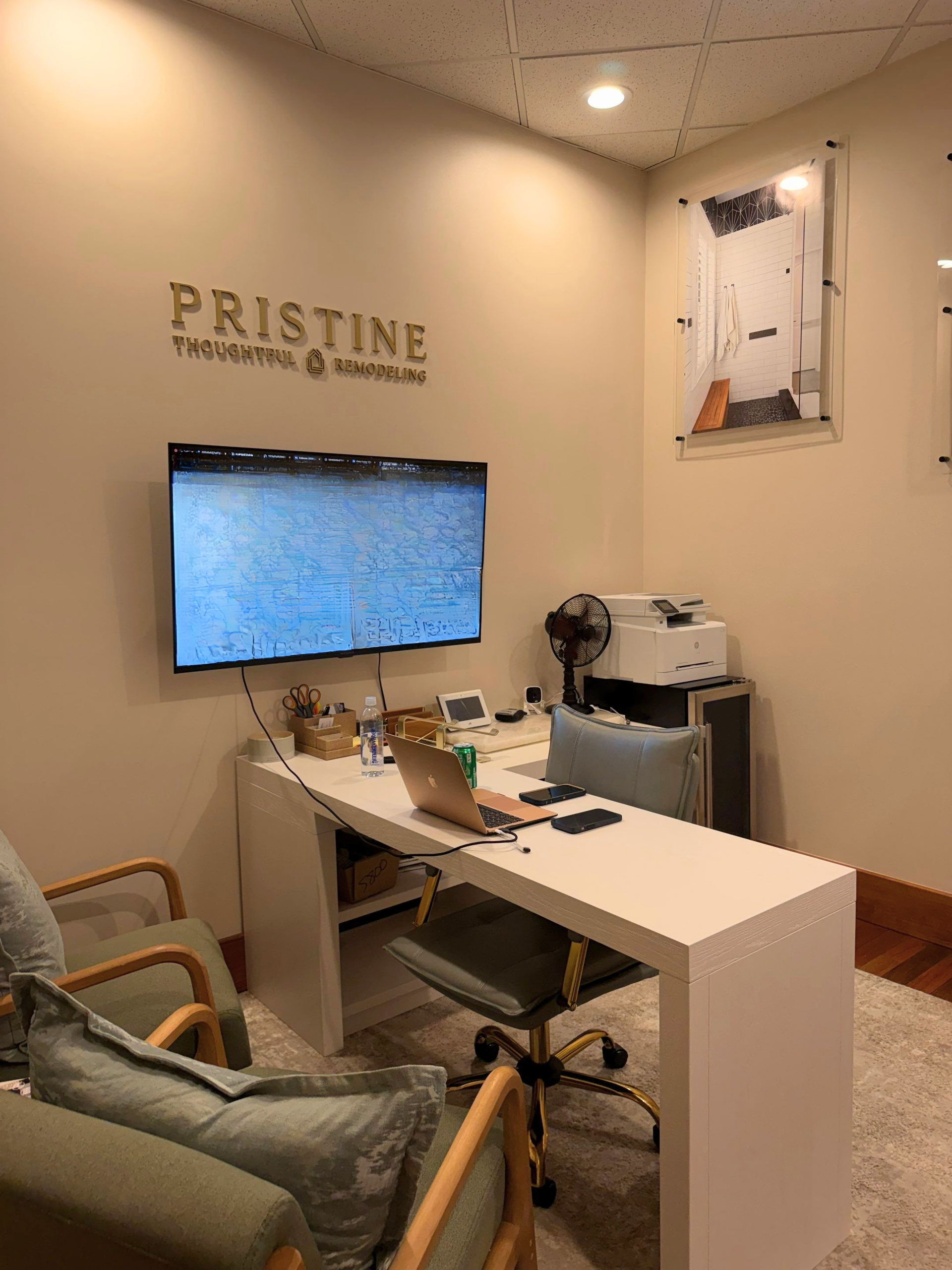 Pristine Aesthetics treatment room with desk, monitor, chairs, and spa equipment