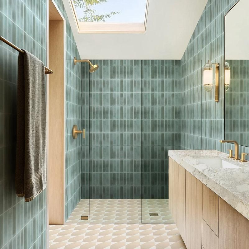 Modern bathroom shower featuring vertically stacked sage green rectangular tiles accented by warm brass fixtures.