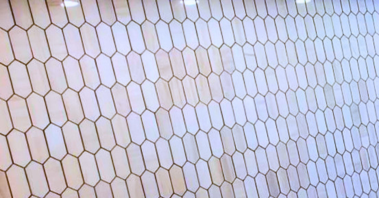 Close-up of a white hexagonal tile or mesh pattern with thin beige outlines
