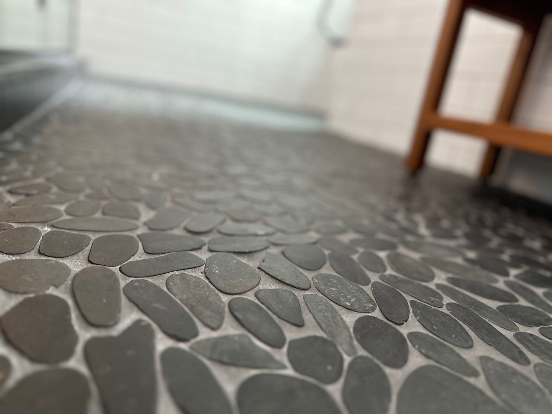 Low-angle view of a pebble-patterned floor with a blurred chair in the background