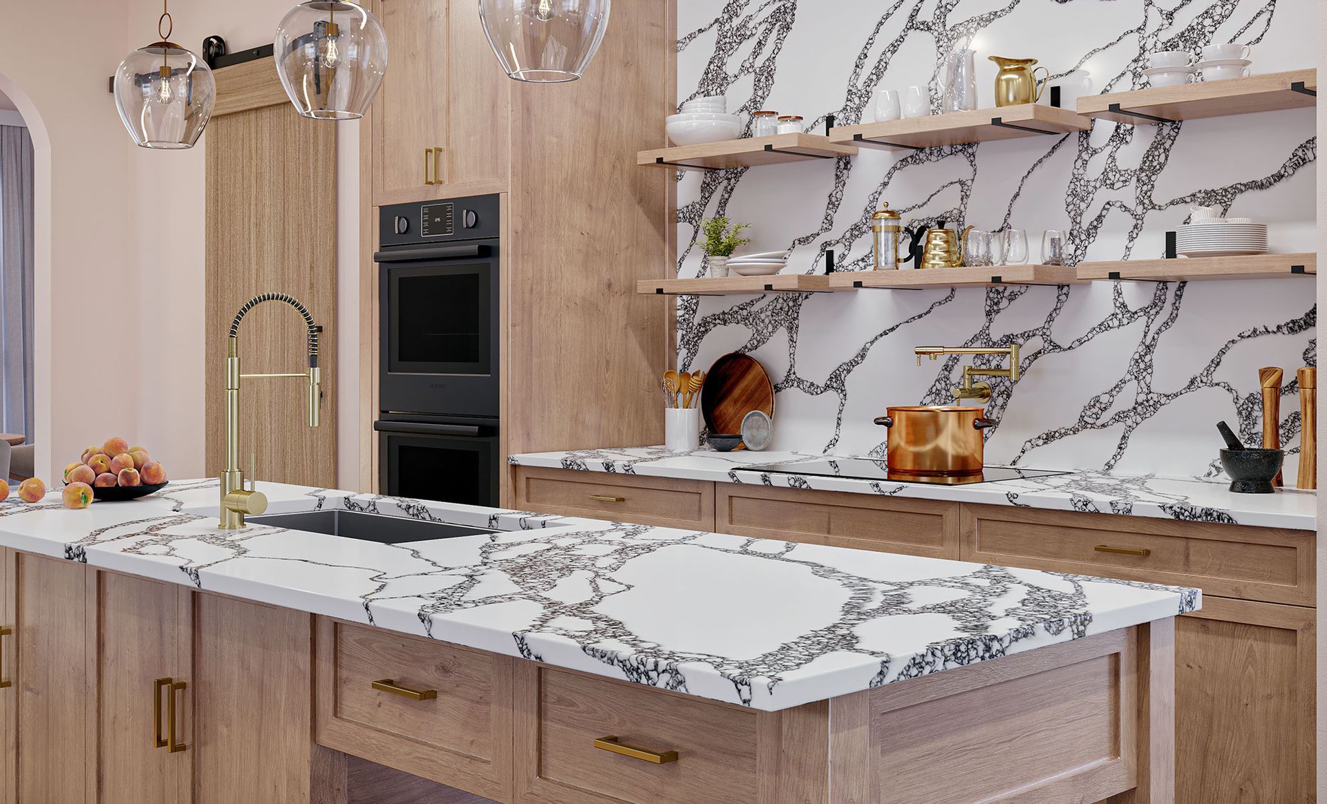 Modern kitchen with marble island, wood cabinets, open shelves, and built-in ovens