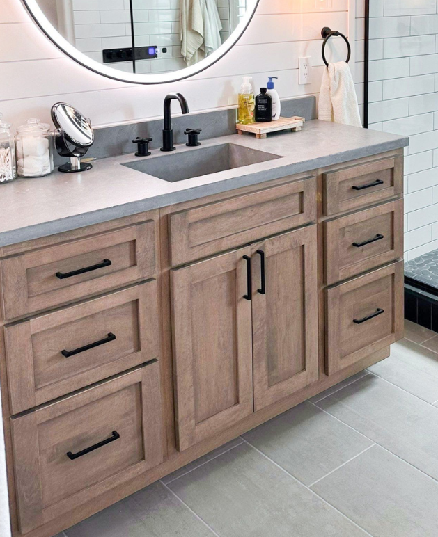 Stained wood bathroom vanity cabinetry with visible wood grain and black hardware