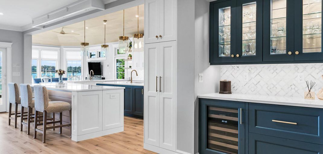 Semi-custom white and navy luxury kitchen cabinets with custom storage and built-in beverage station.