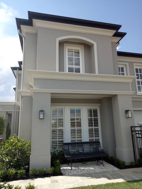 Modern two-story gray house with white trim, front windows, and a small garden path