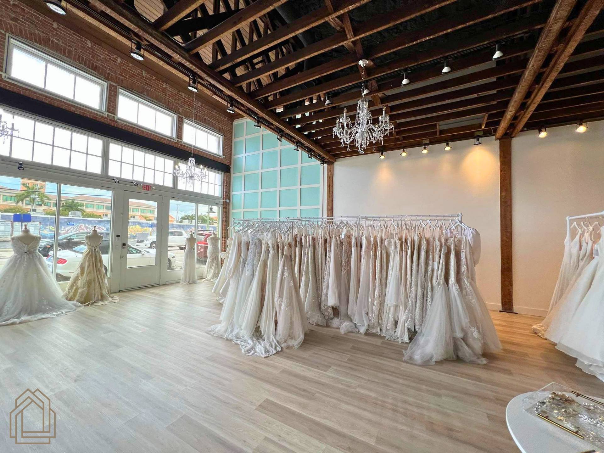 Bridal gown showroom with white dresses on racks in a bright, airy loft space