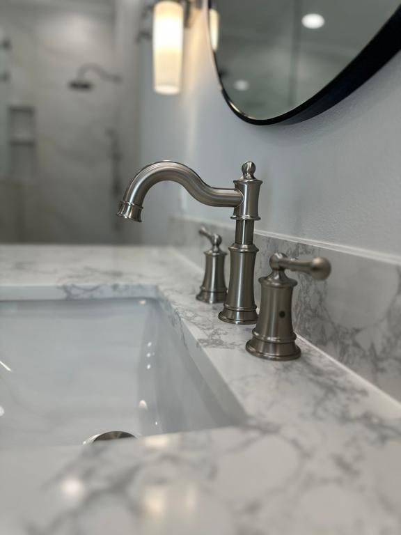Modern brushed nickel bathroom faucet installation in luxury bathroom remodel