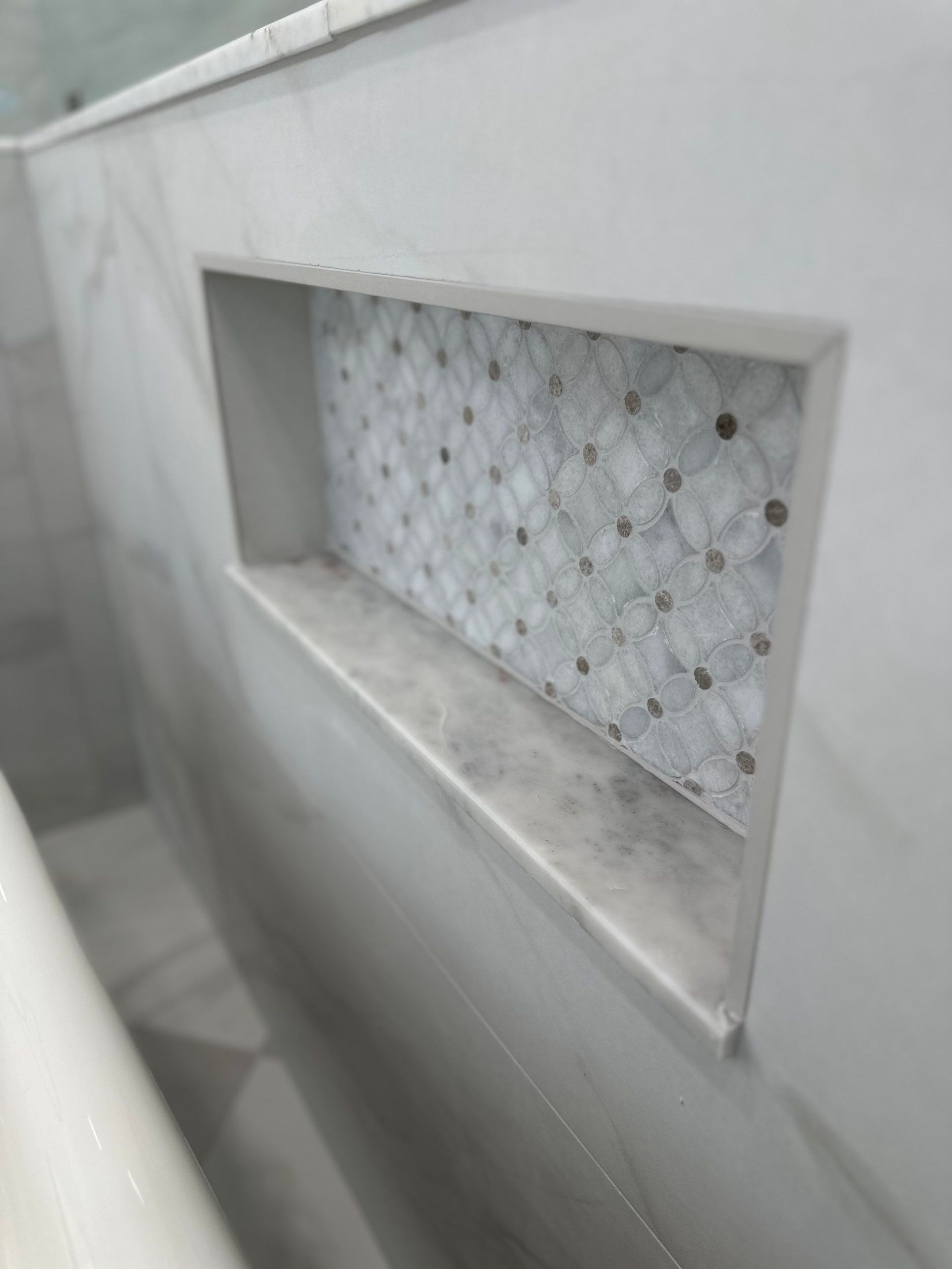 White wall niche with a patterned glass panel in a tiled interior corridor