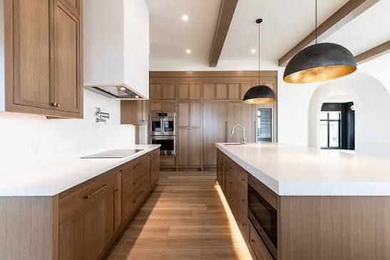Kitchen with warm natural wood cabinetry, light countertops, and simple modern details