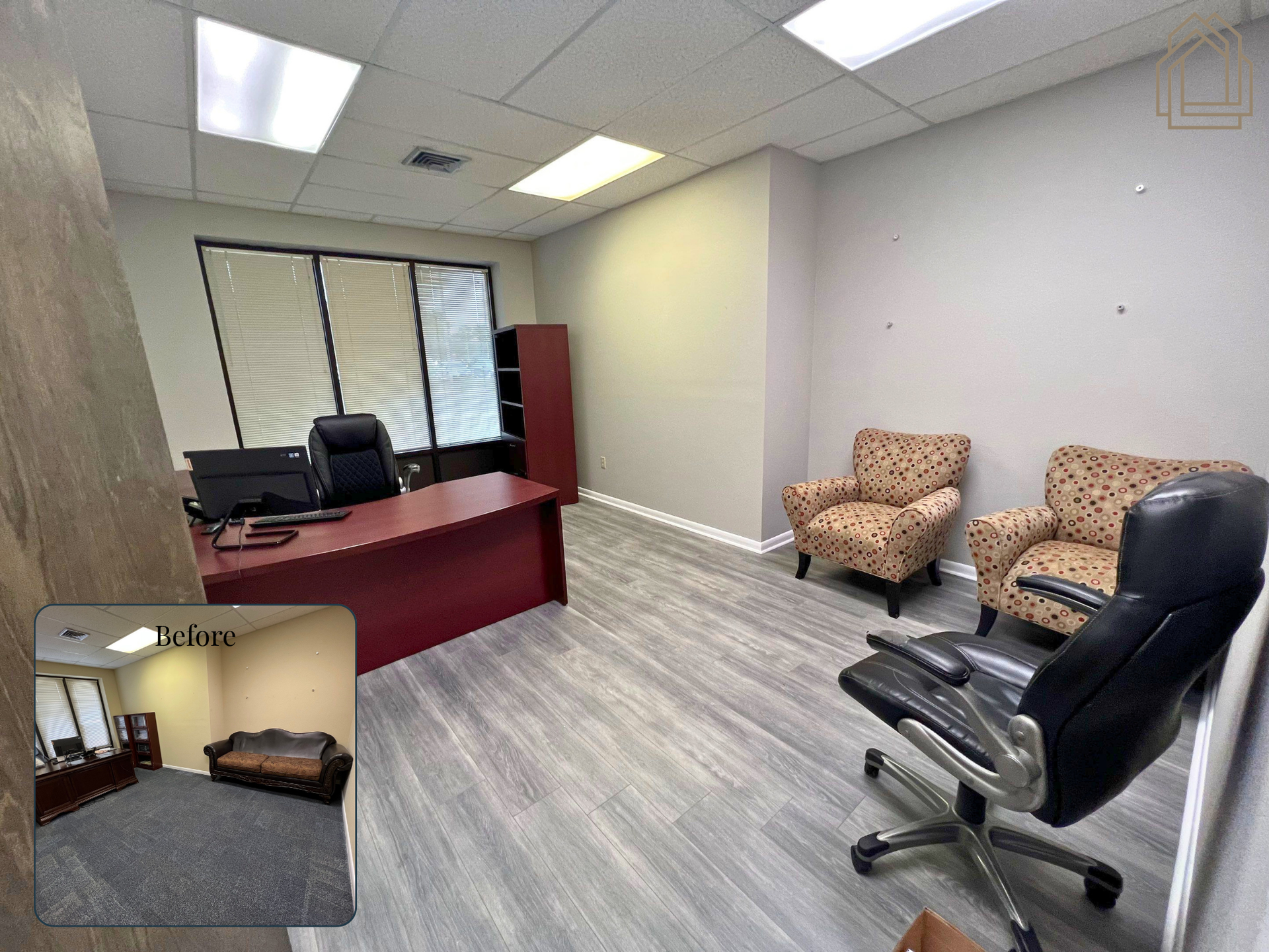 Small office waiting area with desk, chairs, patterned armchairs, and gray wood-look flooring.