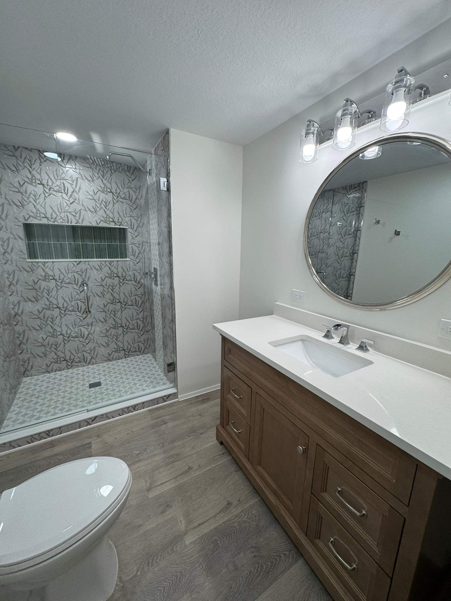 Bathroom remodeling project in Lakeland Florida with modern vanity lighting and decorative tile walls