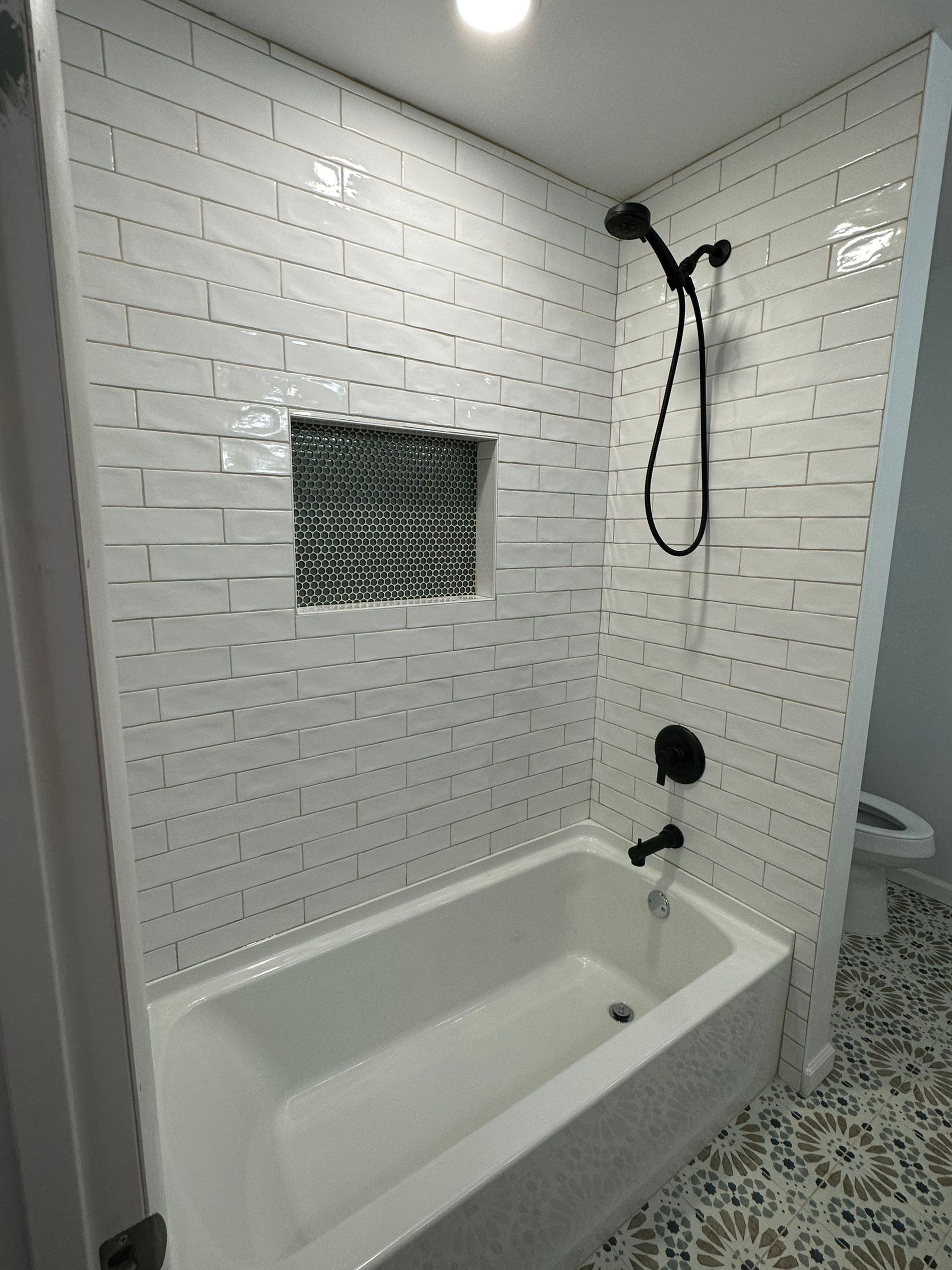 Walk in shower remodel in Central Florida with white subway tile and black shower fixtures