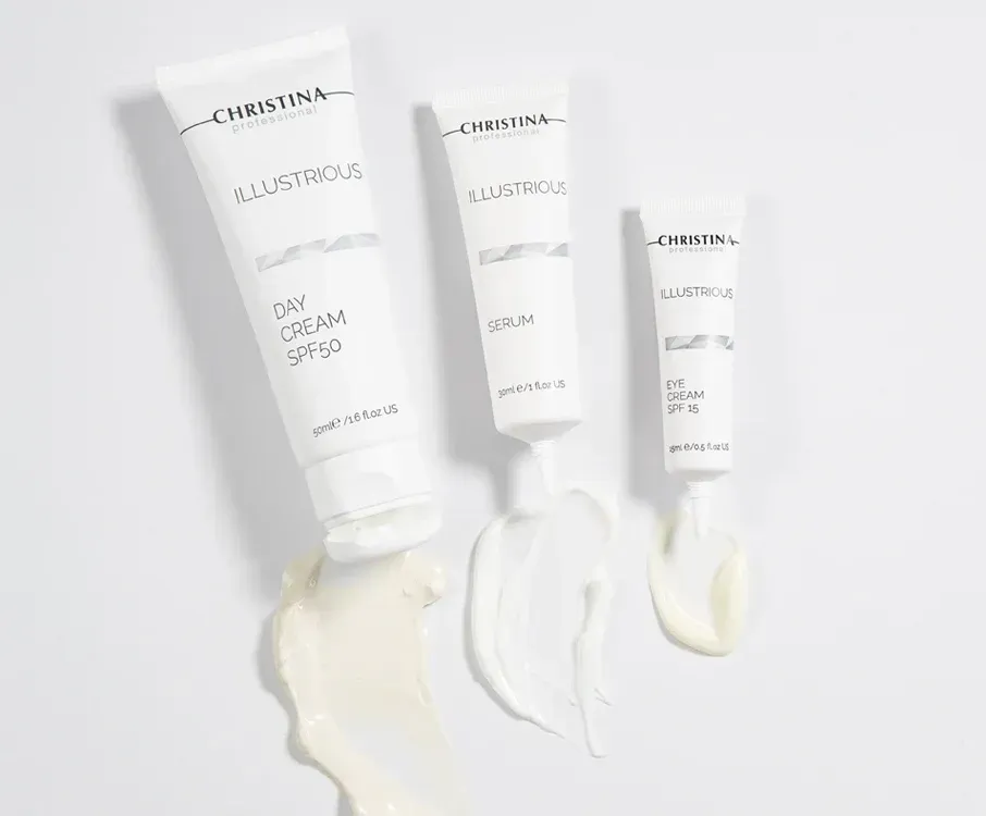Three white skincare tubes with cream swatches on a light background