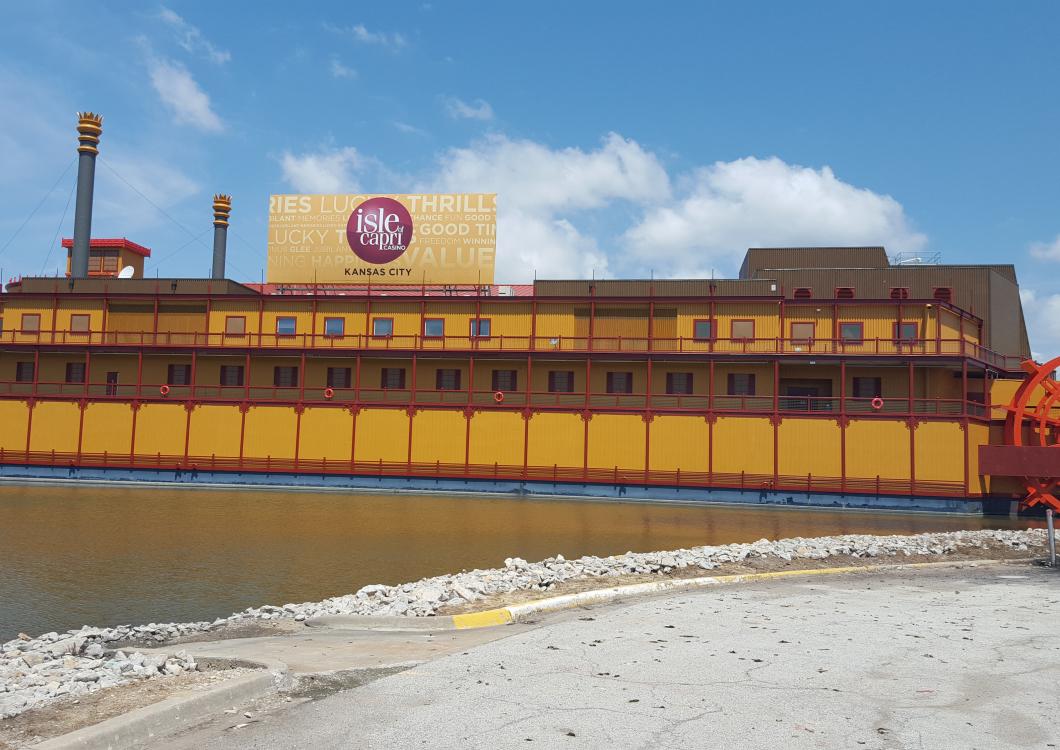 Yellow riverside building with a purple sign, snow-covered ground, and blue sky