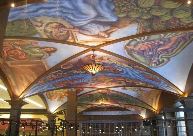 Painted arched ceiling with colorful celestial murals above a lit interior hall