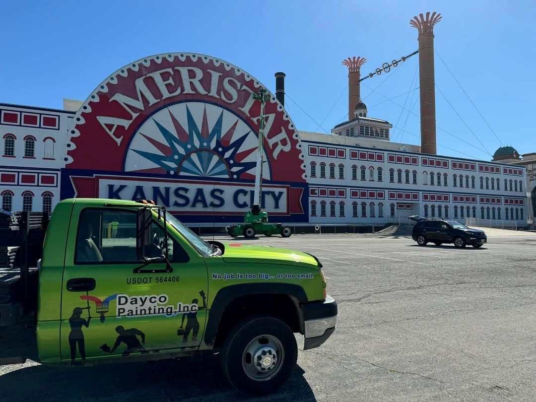 Green truck in front of Ameristar Kansas City sign and building on a sunny day