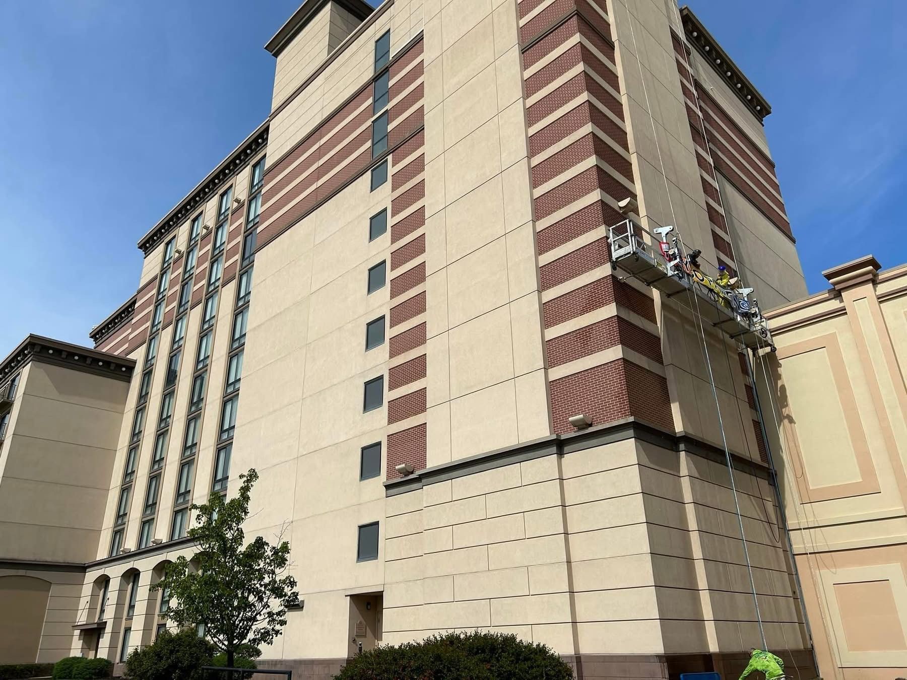 Tall beige-and-red multi-story building against a blue sky