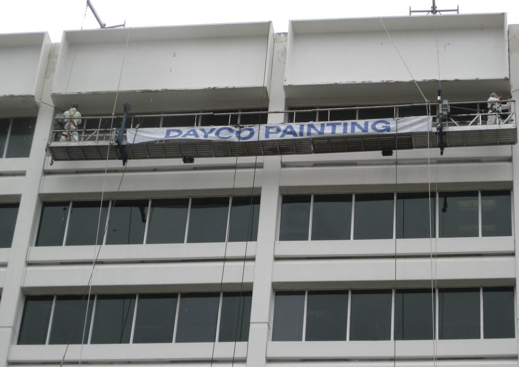 Banner reading “THANKS FOR THE DONATION” on a building balcony with workers and scaffolding above windows