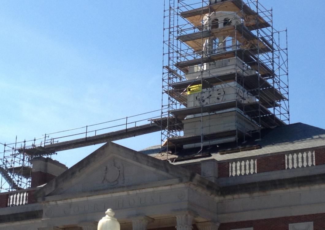 Historic building under renovation with scaffolding against a blue sky