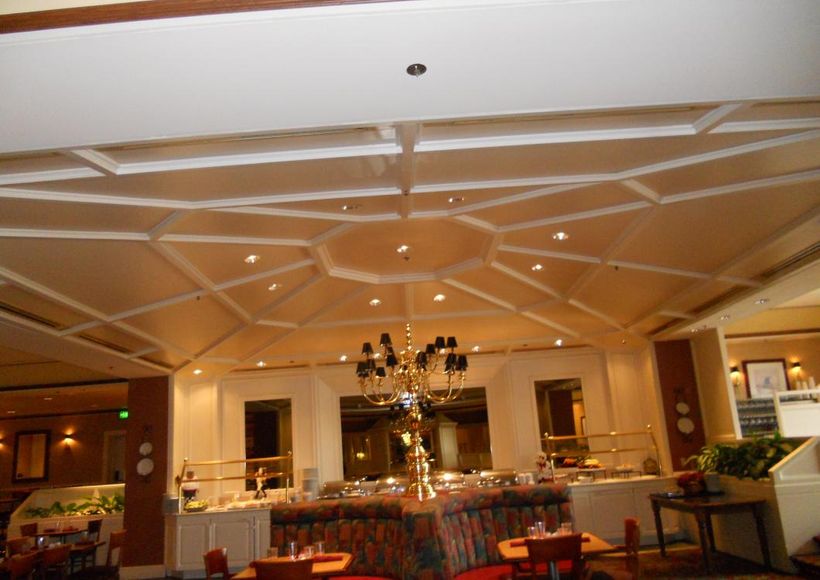 Elegant banquet hall with chandeliers, mirrored wall decor, and set dining tables beneath a vaulted ceiling