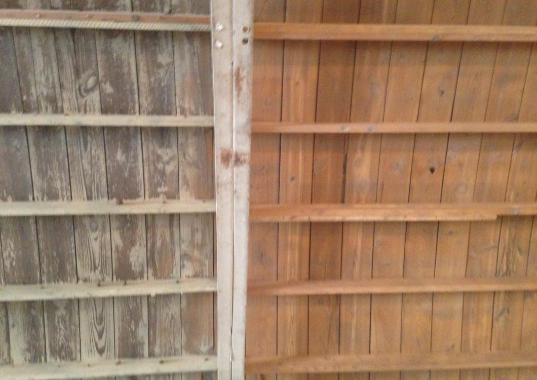 Split view of two weathered wooden fences, gray on the left and warm brown on the right