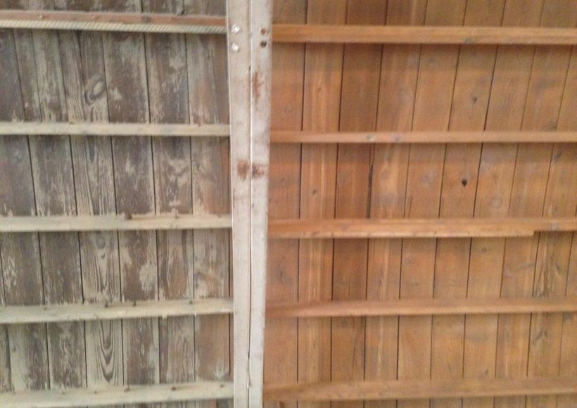 Rustic wooden fence with weathered gray panels on the left and warm brown panels on the right.