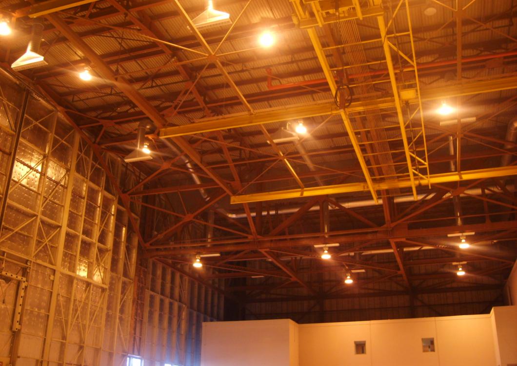 Empty warehouse interior with exposed beams and warm orange lighting