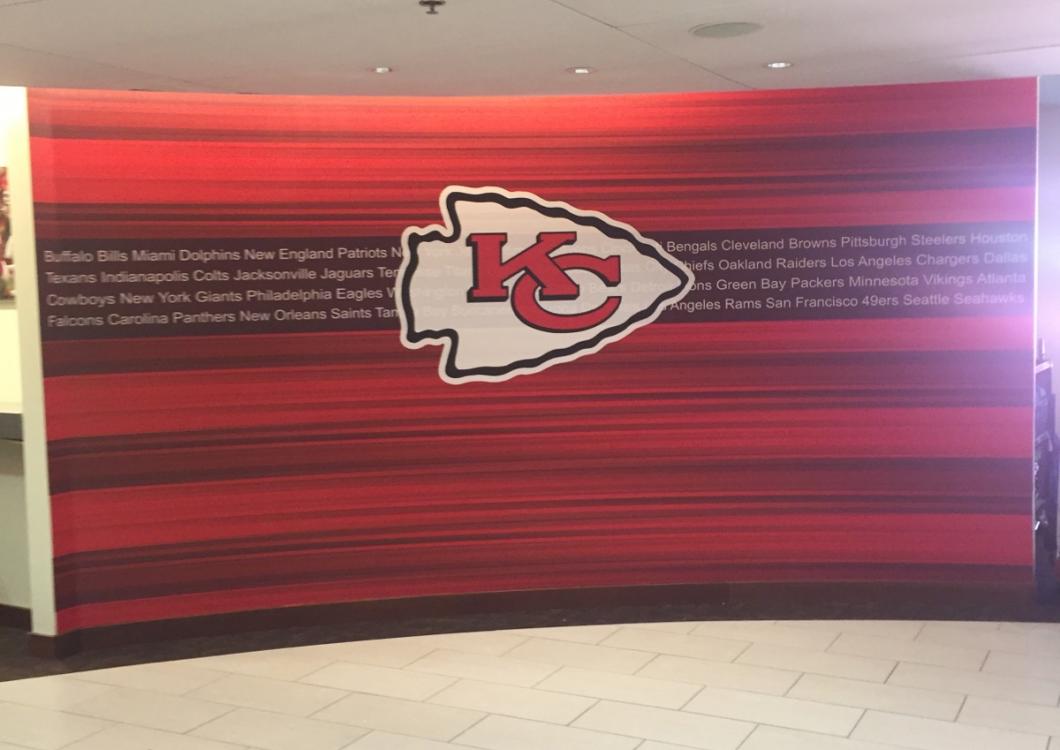 Kansas City Chiefs logo on a red striped wall in a hallway