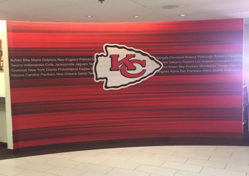 Kansas City Chiefs logo on a red striped wall in a hallway