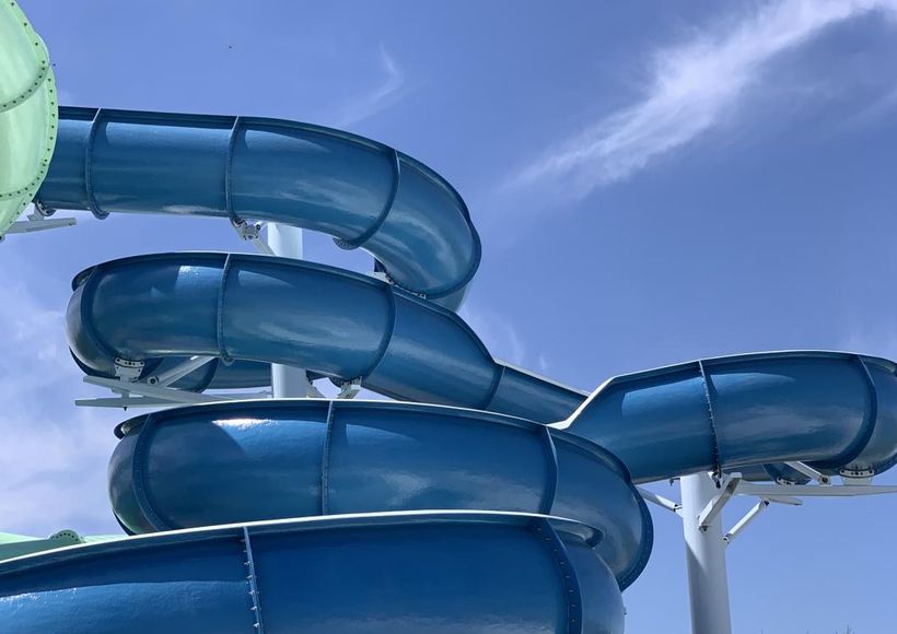 Blue waterslide twists against a clear sky.