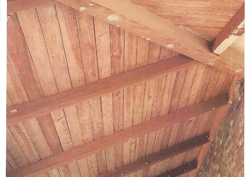 Wooden slatted ceiling with dark beams, viewed from below