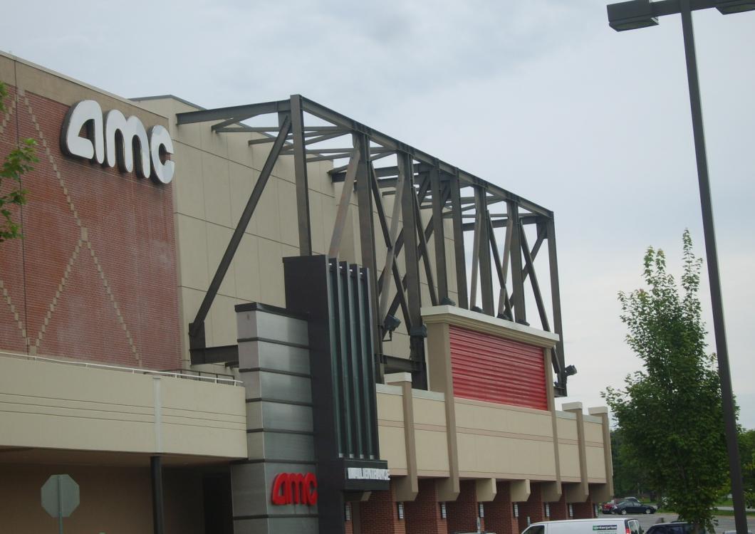 AMC theater exterior with red and beige facade and metal framework signage
