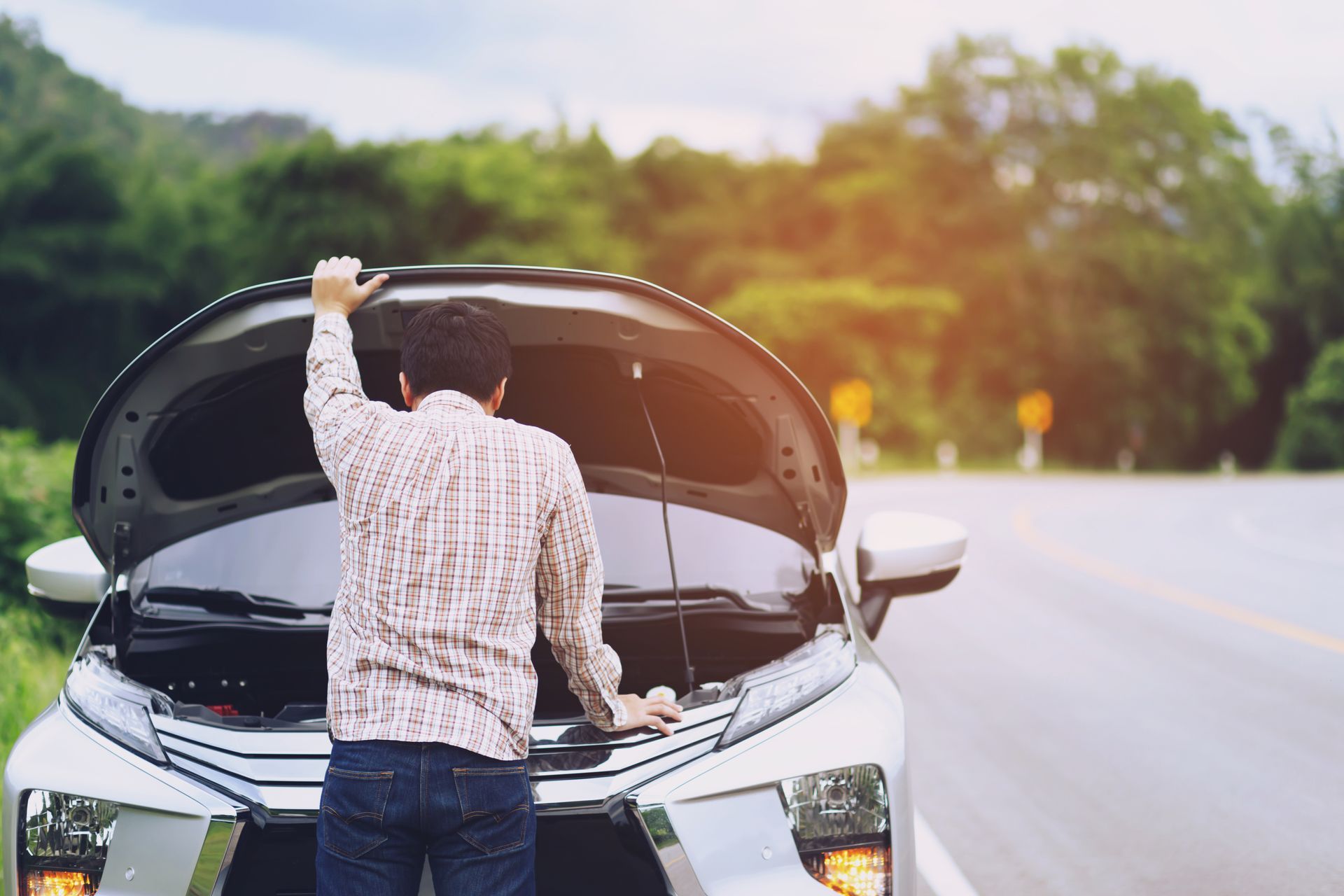 Emergency roadside services for a car with an open hood.