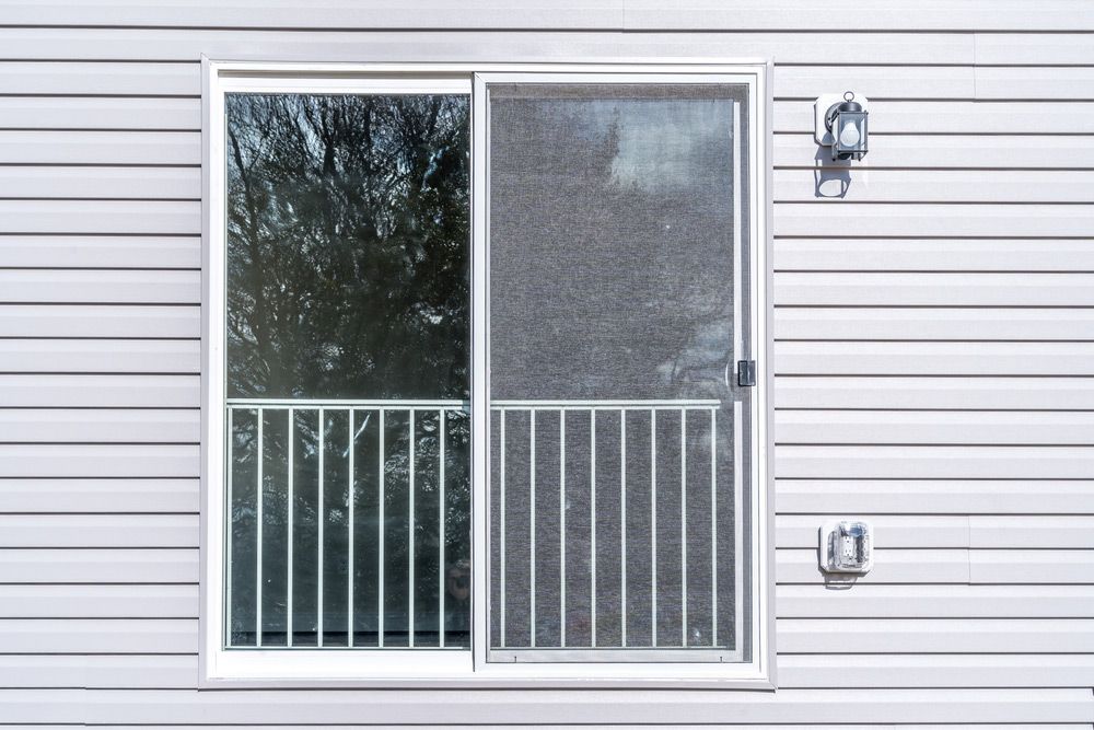 White House With A Sliding Glass Door And A Balcony — Ezi Slide - Glass, Sliding, Track & Security Doors Repair in Ashmore, QLD