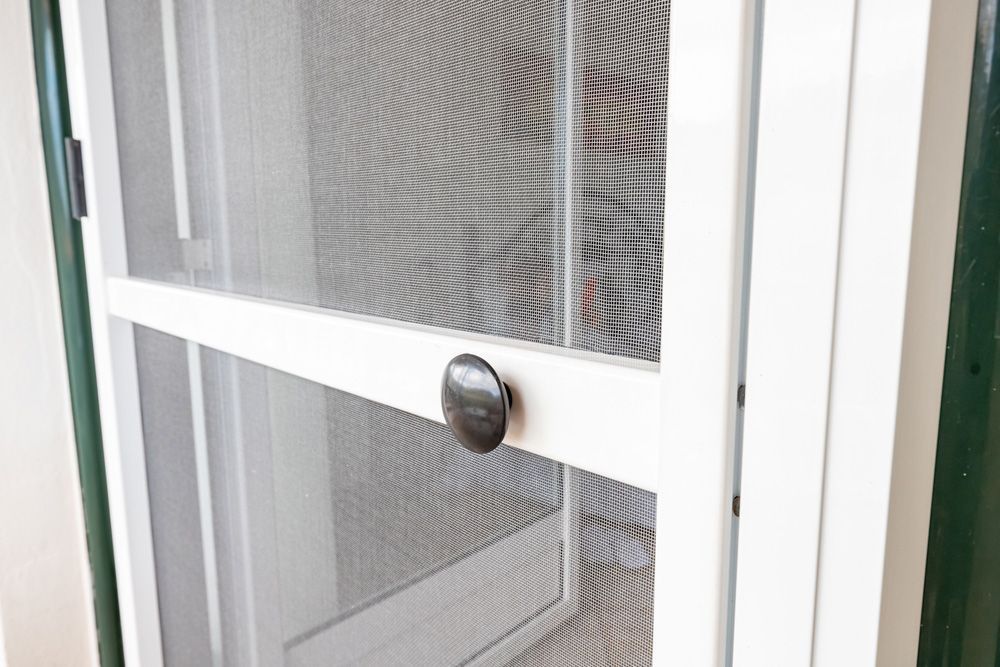 A Close Up Of A White Screen Door With A Black Handle — Ezi Slide - Glass, Sliding, Track & Security Doors Repair in Ashmore, QLD