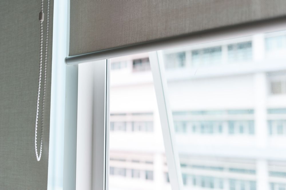 Close Up Of A Roller Blind On A Window With A Building In The Background — Ezi Slide - Glass, Sliding, Track & Security Doors Repair in Ashmore, QLD