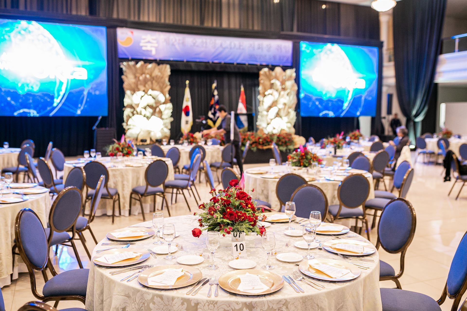 Una gran sala con mesas y sillas preparadas para un banquete.