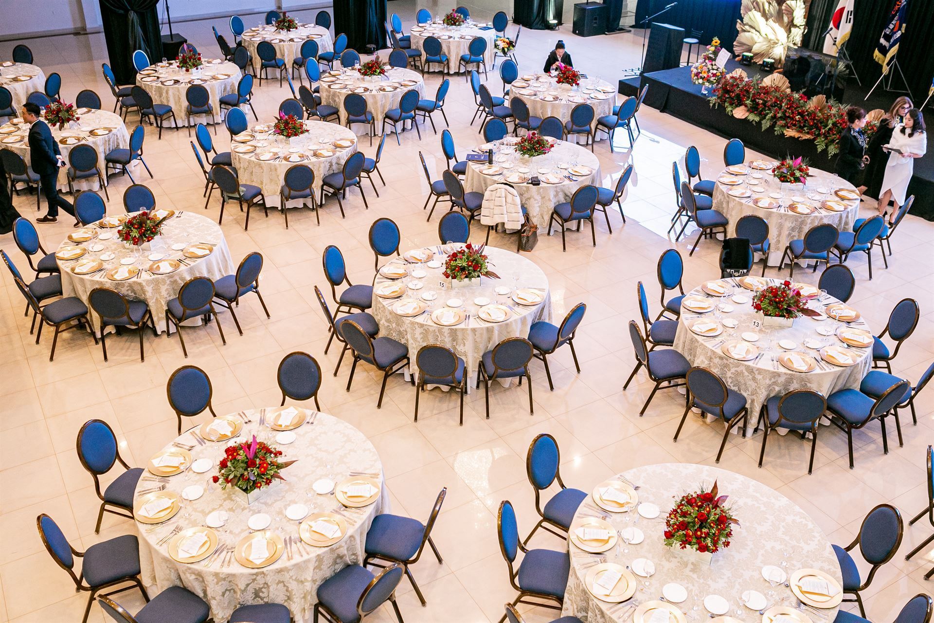 Una gran sala llena de mesas y sillas preparadas para un banquete.