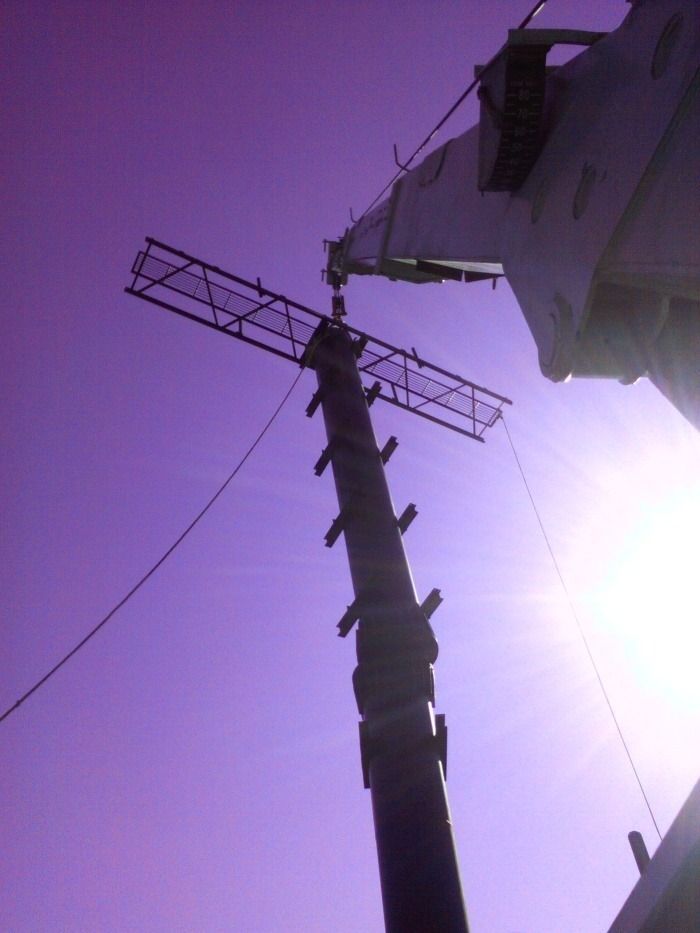 Postes de servicios públicos y líneas eléctricas recortados contra un cielo púrpura brillante al atardecer.